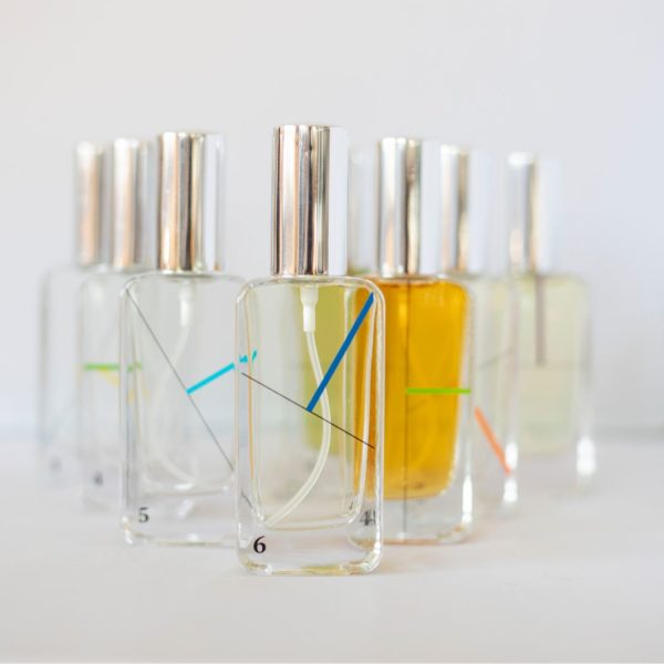 Flacons de parfum alignés aux liquides colorés.
