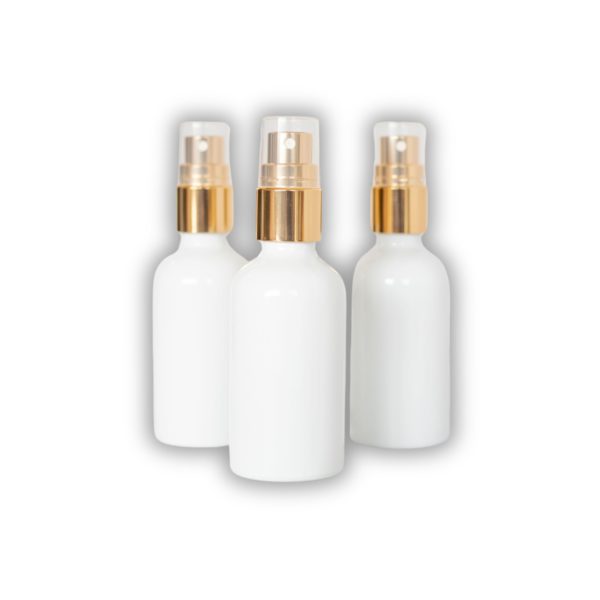 Trois flacons spray cosmétiques blancs.