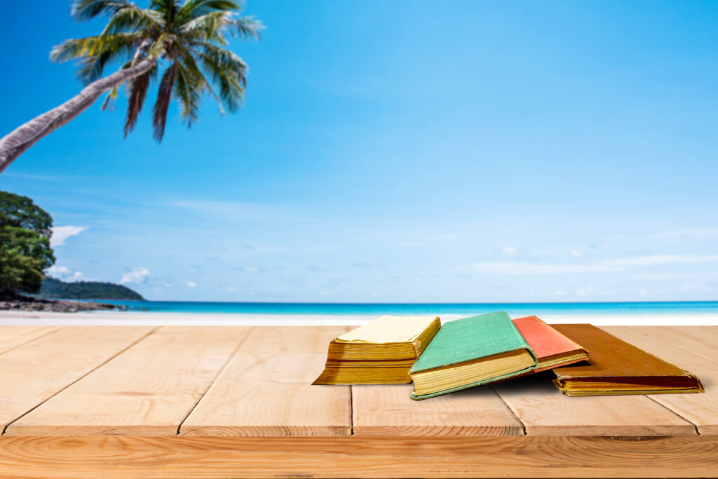 Livres sur table face à plage tropicale